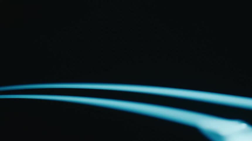 Two curved glowing blue lines spinning against a dark background