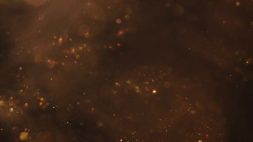 Golden particles floating in dark water