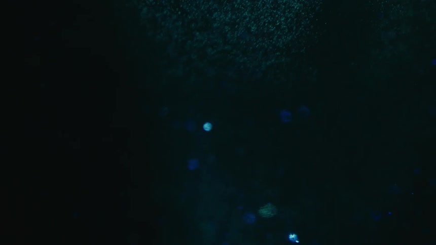 Small disks floating through a dark fluid shimmer a blue color