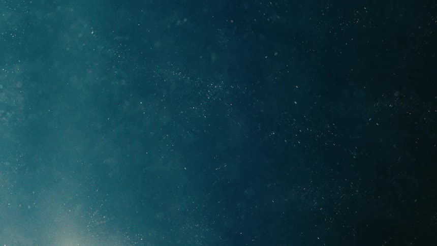 A dark blue liquid with small white particles floating in it