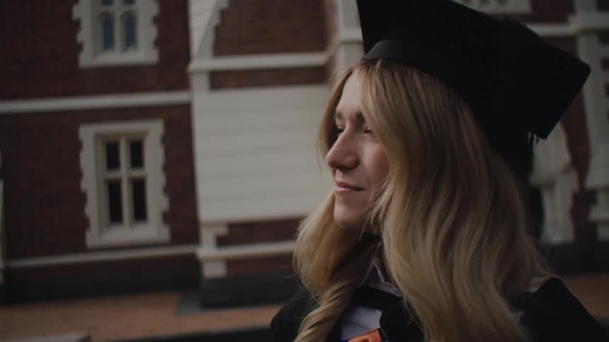 Portrait of a student wearing a graduation gown and with a happy facial expression