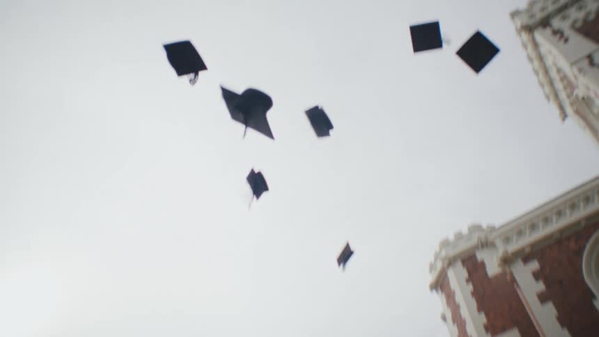 Students throwing their graduation caps into the air