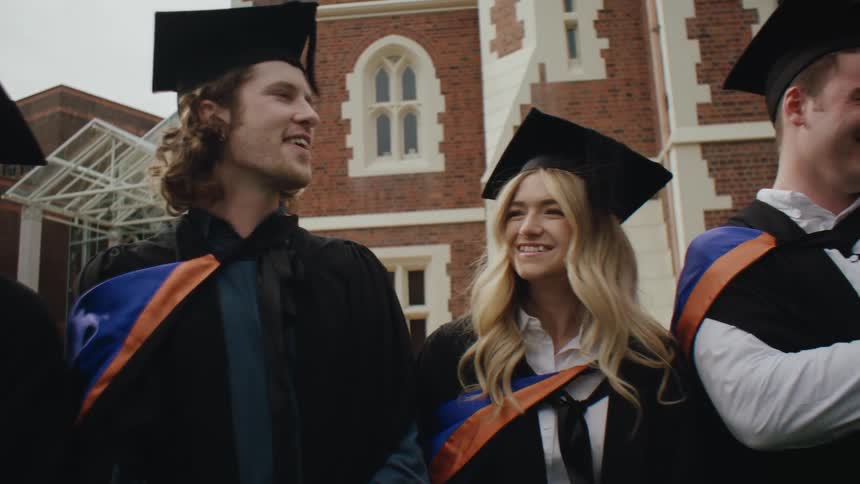 College students with cheerful graduation gowns