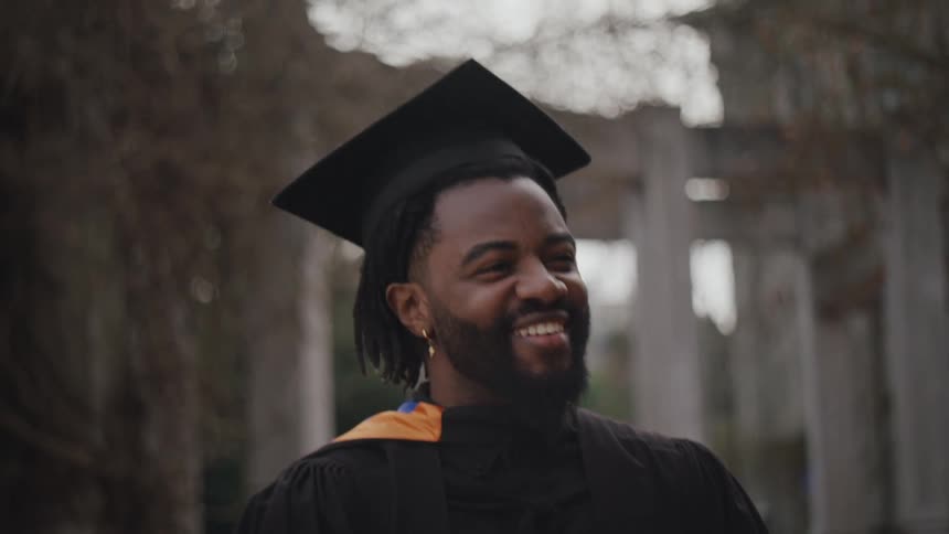 Bearded man wearing a gown talking to other people