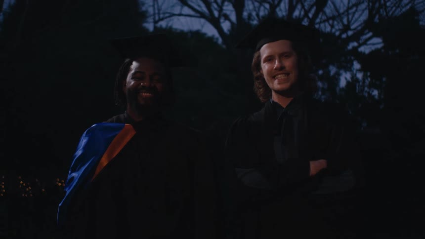 Two men posing with graduation gowns