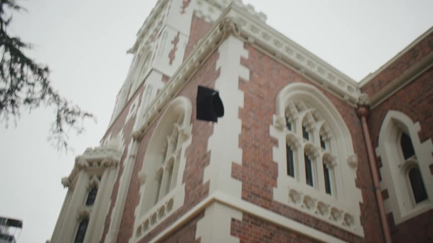 A graduate student throwing her hat in the air