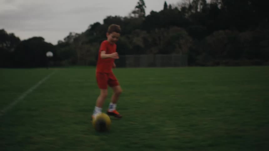 Children practicing soccer on a green field