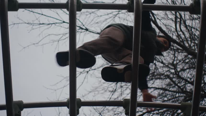 Overhead view of a little boy playing on a playground toy on a cloudy day