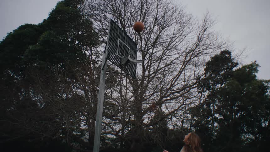 Young friendsplay basketball on an outside court in the park