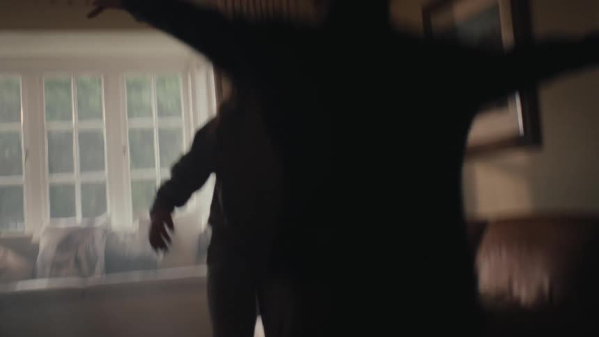Two people in the living room hugging each other happily