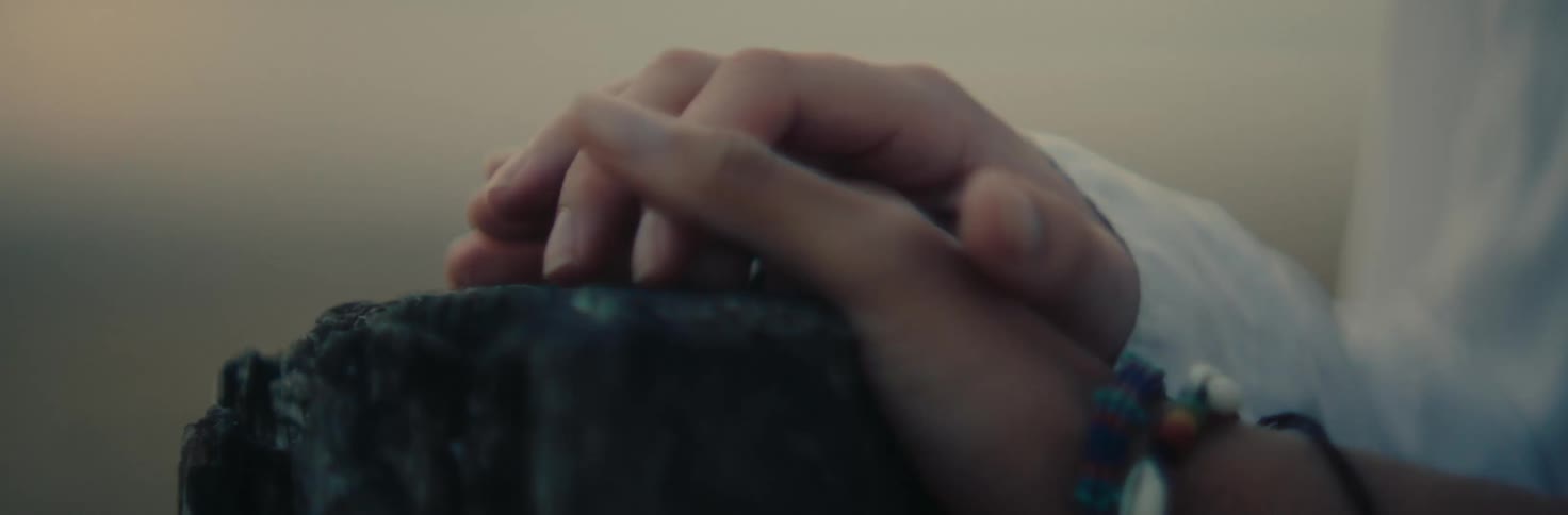 Two hands one rough and weathered the other smooth and delicate intertwine in a gesture of comfort and understanding