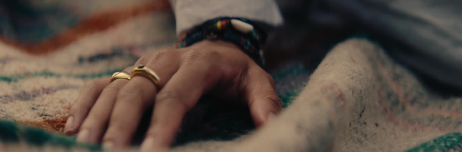 Person wearing two rings strokes a blanket