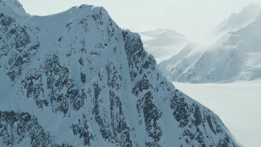 Haze hovering over snow covered mountain peaks