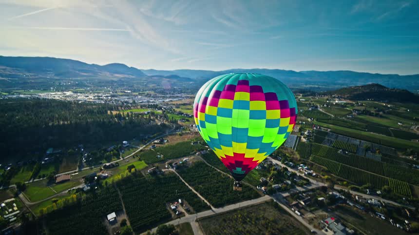 Lovely panorama of a colorful balloon flying above plateau and mountains