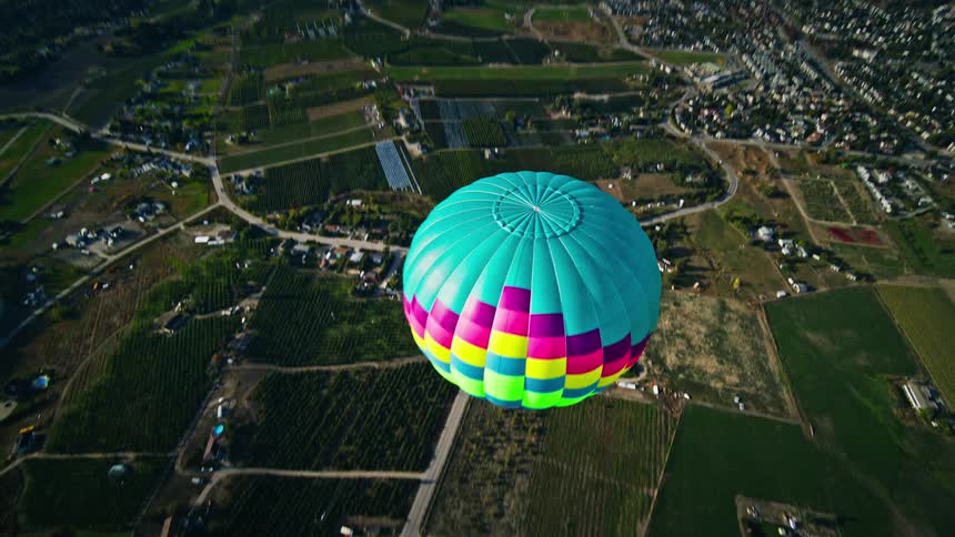 Aerial panorama of a colorful balloon flying above a mountain town