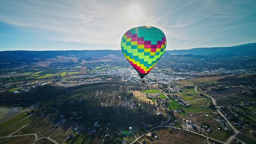 Aerial panorama of a large balloon flying above an urban city