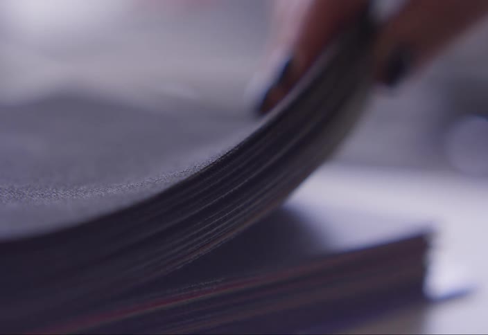 Hand holding sulfite sheets on a table