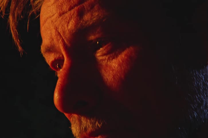 Portrait of a man with watery eyes outdoors at night