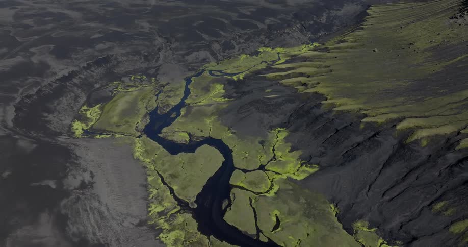 A winding river flows through a rugged volcanic landscape