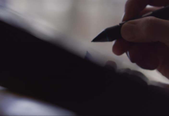 Close up of a person drawing on a digital tablet