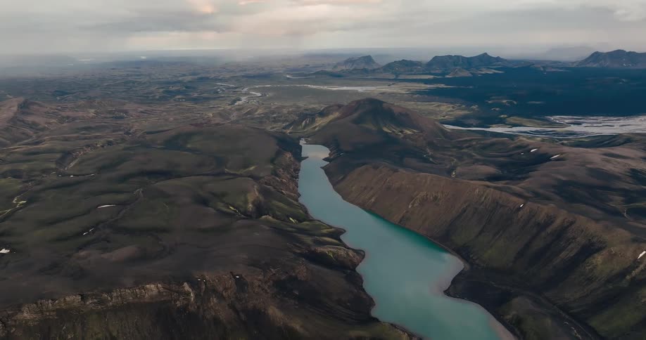 A winding river flows through a rugged volcanic landscape