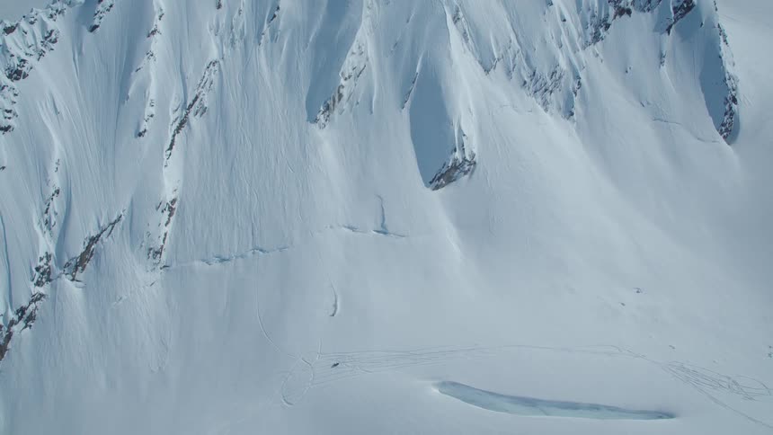 Aerial view of a person skiing down a snowy mountain