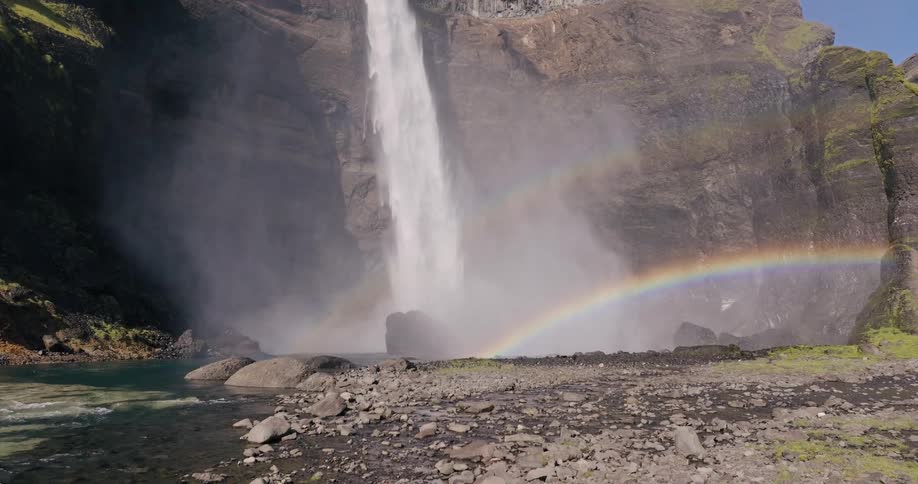 Landscape of a rainbow over a waterfall in a rocky valley