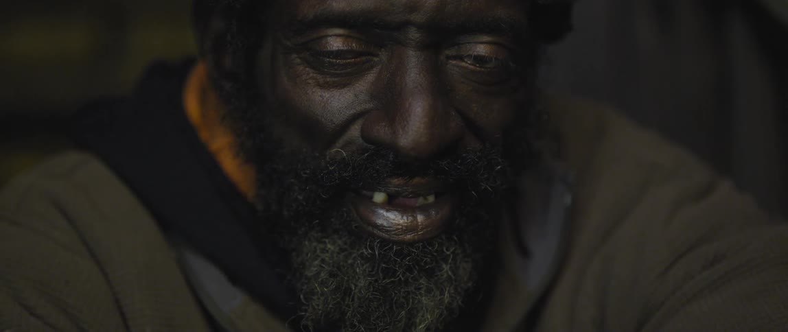 A man with with a beard opens his eyes and blinks