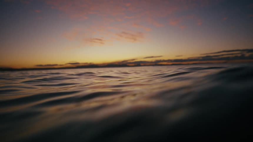 A sunset with warm hues of orange and blue over a calm ocean