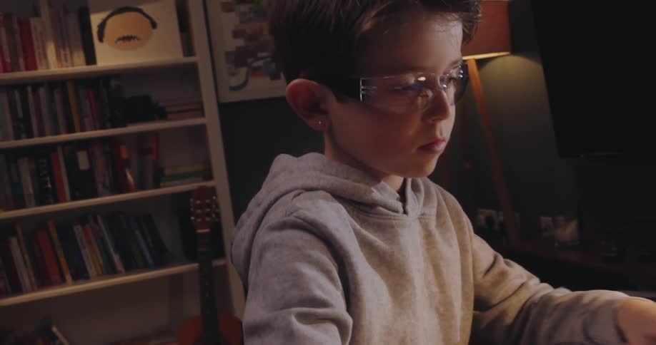 Boy dragging and opening a laptop on the table