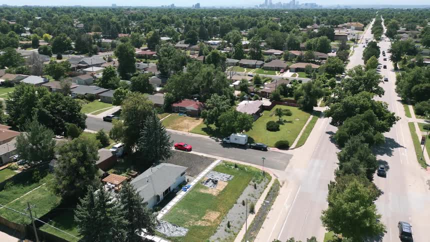Traffic drives down roads inside of a suburb