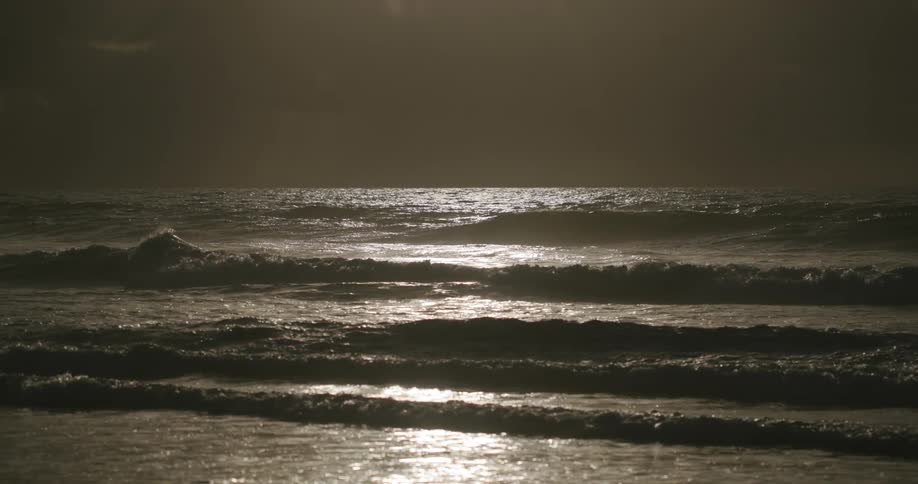 Waves on the beach with reflection of the sun