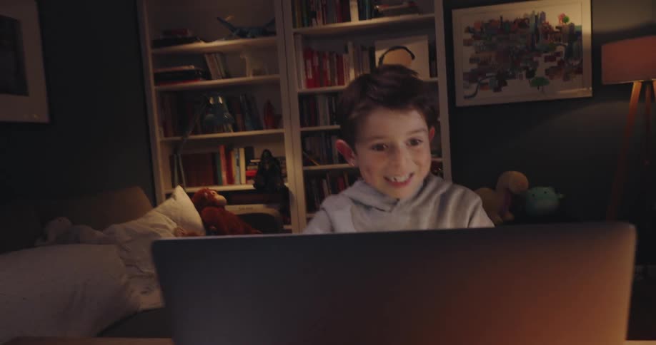 Boy sitting at table vibrating in front of laptop