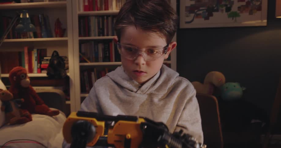 Portrait of a little boy working on a mechanical arm