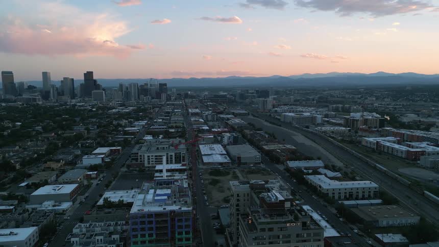 A view of denvers skyline with the rocky mountains in the background
