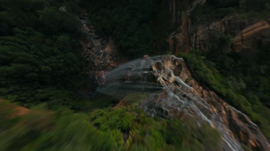 Aerial view of a cascading waterfall amid lush vegetation
