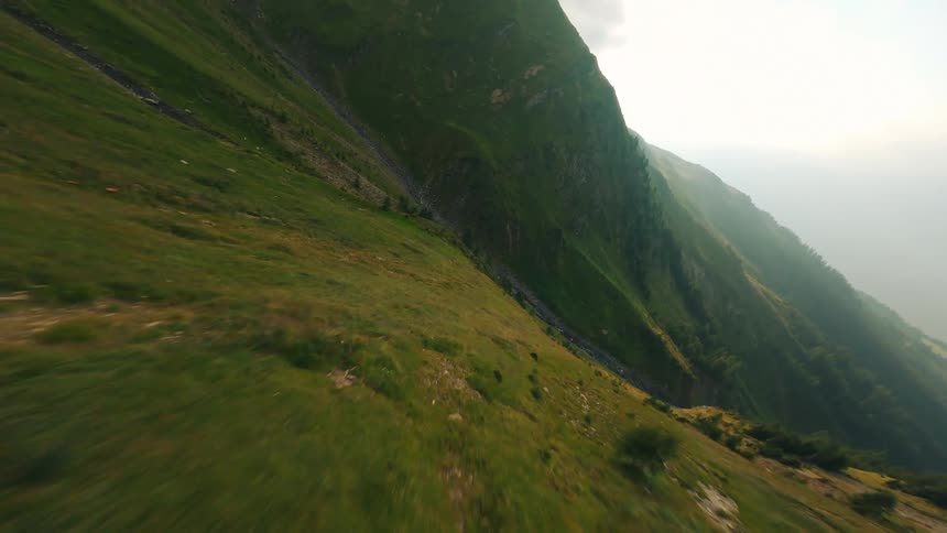 Aerial View of a Mountain Ridge Line Ending in a Cliff Overlooking a Foggy Valley