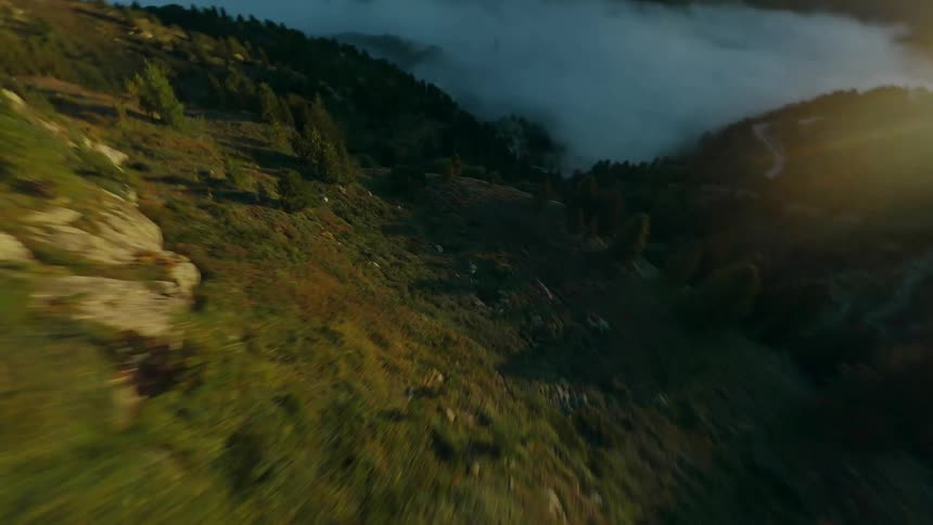 Dynamic clip flying down a mountain towards an ocean of clouds with an FPV drone