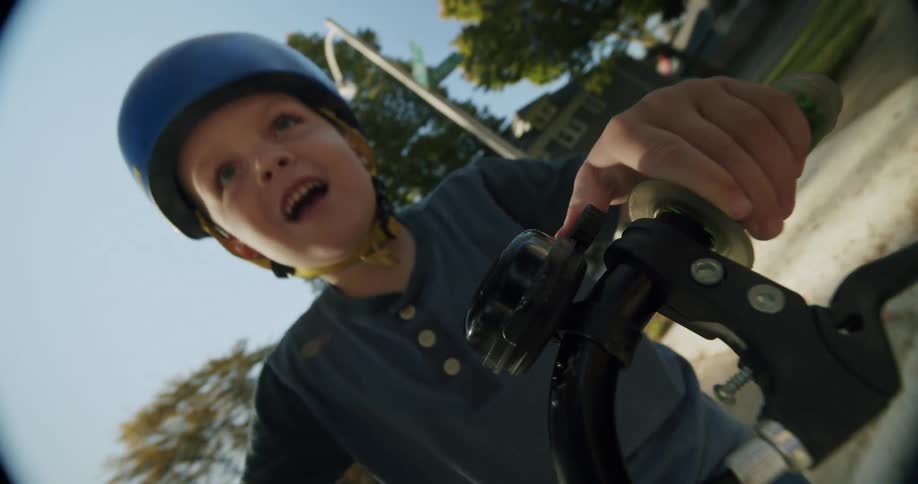 A child wearing a helmet rides a bicycle in the neighborhood during fall