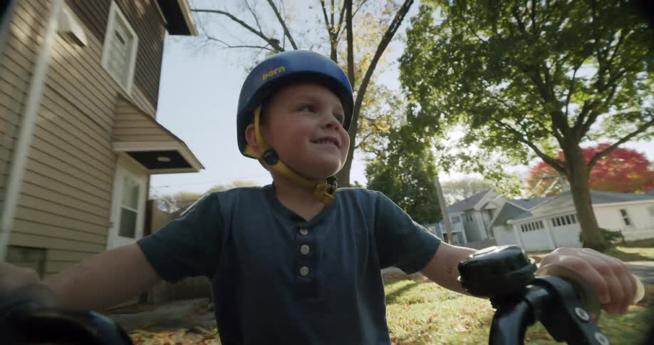 Boy wearing a helmet riding a bike in a residential neighborhood