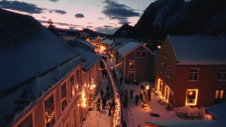 Aerial of people walking through a village at a resort at night