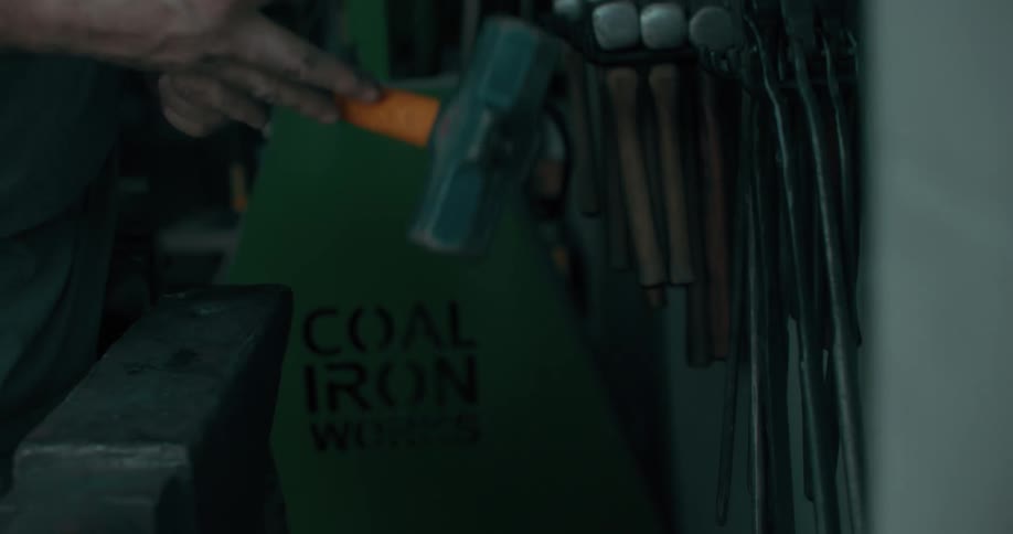 Man selects tools from items stored near a wall