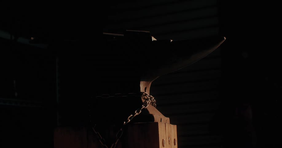 Sunlight filtering into a dark room and illuminating a metal tool attached to a chain