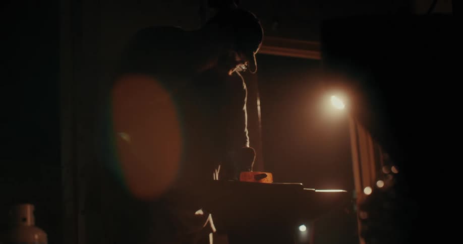Silhouette of a man with a hammer forging a heated metal