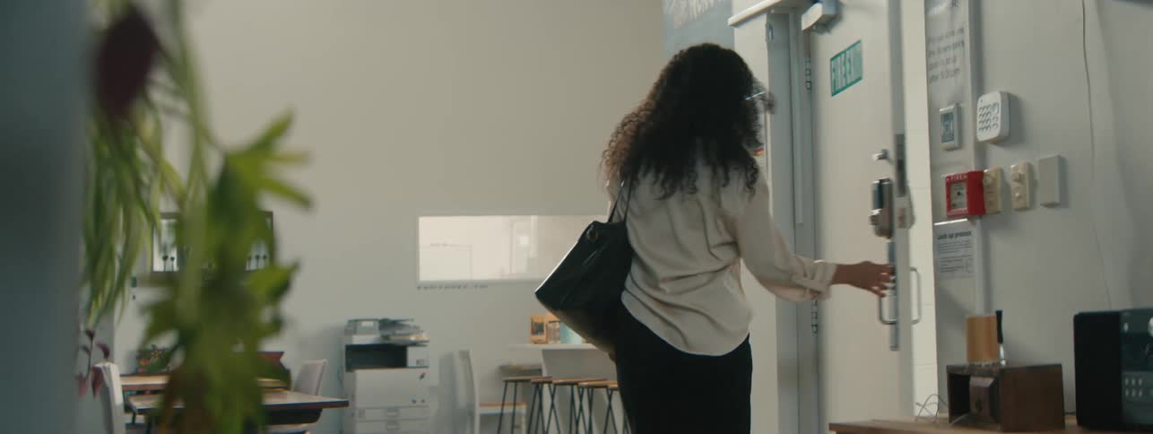 Woman opening the door and entering an office room