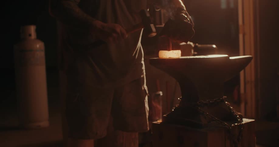 Man with hammer forging a heated metal