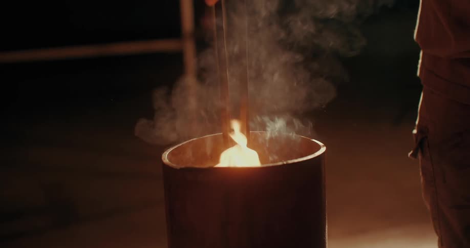 A blacksmith dips hot metal in water