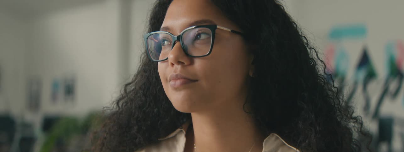 A woman wearing glasses is smiling
