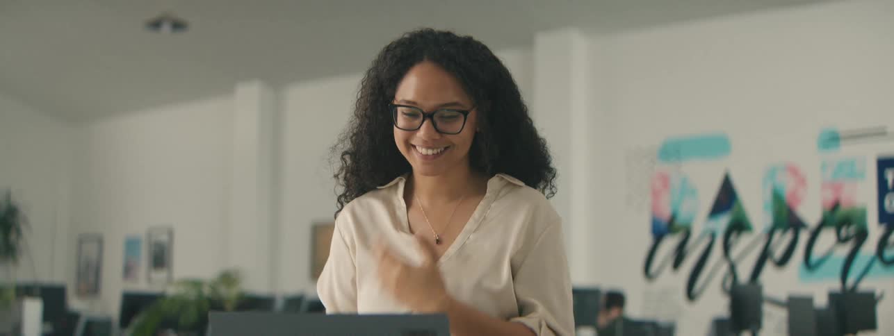 Woman talking in front of a laptop and while in an office environment