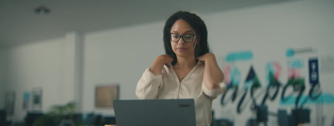 Woman drinking from a mug and chatting happily with an open laptop